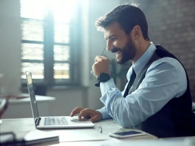 side-view-happy-businessman-using-computer-while-working-office